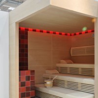 Finnische Sauna mit trendiger Ofenverkleidung aus Keramik und indirekter LED Hinterleuchtung