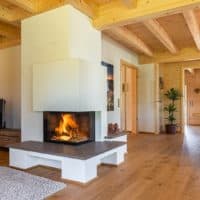 Kamin Ecke Eckkamin verputzt Kamineinsatz Kamin Raumtrenner modern Holzfach Holzlege