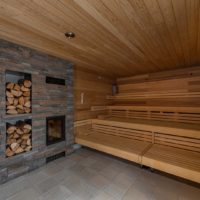 Thermalbad Aukammtal Wiesbaden: Feuersauna mit Kamin aus Naturstein und Holzlager