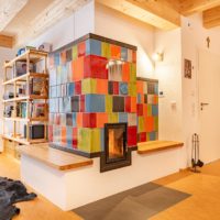 bunter Design-Kachelofen (Grundofen) individuell mit Kacheln in unterschiedlichen Farben unterschiedlich glasiert.