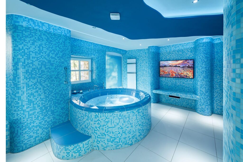 Im Erdgeschoss eines Hauses bei einem Schloss entstand ein außergewöhnliches Spa in verschiedenen Blautönen. Herzstück ist ein runder Whirlpool mit sanften, ergonomischen Formen, handgefertigtem Keramikbeckenrand und zwölf Jetdüsen. Ergänzt wird die Wellnessoase durch ein Dampfbad mit Wärmebank.