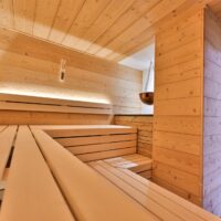 Eine Kupferschale über dem Ofen der Sauna enthält den wohlriechenden Kräutersud. Die untere Bank der Kräutersauna ist verschiebbar für einen Rollstuhl-Platz